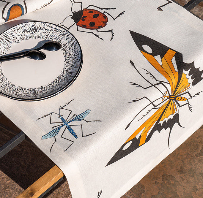 Tablecloth with insect designs on a table setting