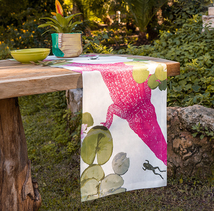 Table with a colorful tablecloth featuring a cactus design in an outdoor setting.